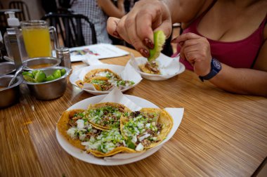 Meksika 'da tacos al pastor yiyen Meksikalı kadın, Latin Amerika' da Meksika yemeği.