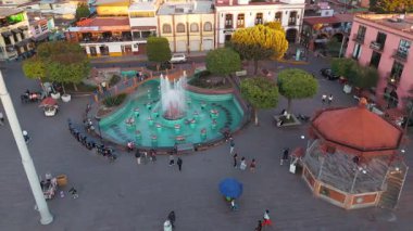 Meksika Metepec 'teki Calvary Kilisesi' nin görkemli bir şekilde tepenin üzerinde durduğu dinamik bir zaman dilimi. Dizide ayrıca geleneksel büfe ve ünlü Denizkızı Çeşmesi 'nin vurgulandığı pitoresk ana plazayı da sergiliyor.