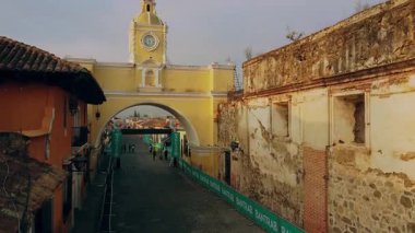Antigua Guatemala 'daki Santa Catalina Kemeri' ni sinema ve tarihi sokak bağlamında gösteren pürüzsüz drone çekimi, belgesel veya seyahat filmleri için ideal.