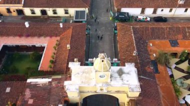 Antigua Guatemala 'daki ikonik Santa Catalina Kemeri' ne yaklaşan insansız hava aracı hareketinin koloni binaları ve volkan arkaplanı seyahat ve mimari görüntüler için mükemmel..