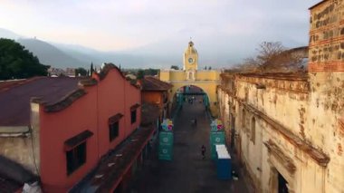 Antigua Guatemala 'daki ikonik Santa Catalina Kemeri' ne yaklaşan insansız hava aracı hareketinin koloni binaları ve volkan arkaplanı seyahat ve mimari görüntüler için mükemmel..