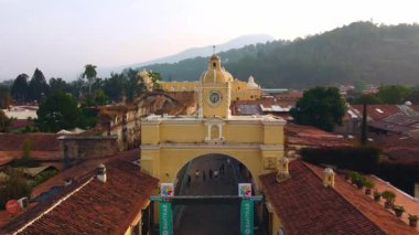 Antigua Guatemala 'daki ikonik Santa Catalina Kemeri' ne yaklaşan insansız hava aracı hareketinin koloni binaları ve volkan arkaplanı seyahat ve mimari görüntüler için mükemmel..