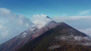 Guatemalas 'ın aktif Fuego Volkanı' nın gökyüzüne doğru yükselen duman ve kül bulutlarıyla çevrili havadan görüntüsü sinematik ve doğa görselleri için mükemmeldir..