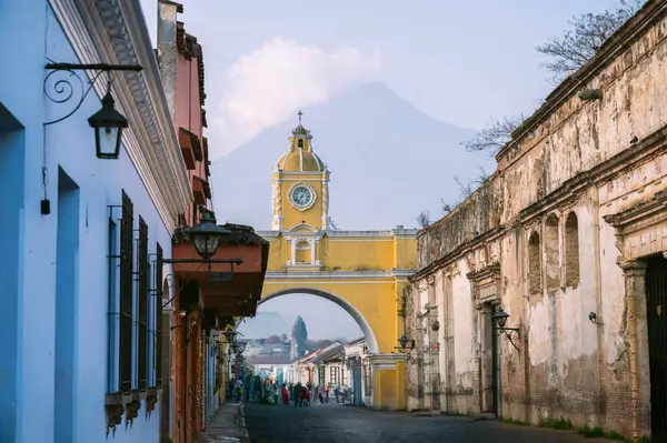 Antigua Guatemala 'nın üzerinde sabah ışığı Santa Catalina Kemeri ve uzak volkan, huzurlu bir atmosferde koloni sokakları ve canlı mimari ile.