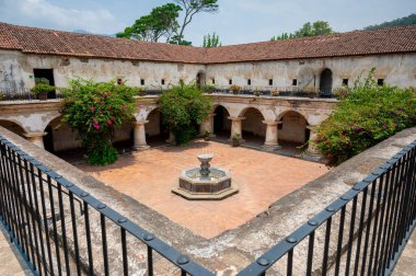 Capuchinas Manastırı 'ndaki avlunun ortasındaki dairesel fıskiyenin üst manzarası Antigua Guatemala' daki tarihi kemerler ve koloni mimarisi ile çevrilidir..