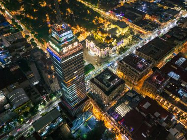 Mexico City şehir merkezinin göz kamaştırıcı gece fotoğrafı aydınlanmış gökdelenleri ve parlak ışıkları olan ikonik binaları gösteriyor. Şehir mimarisi, kültür ve şehir hayatı dramatik bir ufuk çizgisi görünümünde.