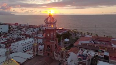 İHA görüntüleri, Puerto Vallarta, Jalisco 'daki Guadalupe Kilisesi' nin büyüleyici mimarisini gösteriyor. Video, kiliselerin ikonik taç kulesini çekiyor. Güneş Pasifik Okyanusu 'nda batarken. Kültür, gelenek ve doğayı harmanlıyor.