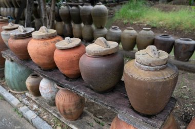 Several antique terracotta jars with wooden lids on the background, interior decoration