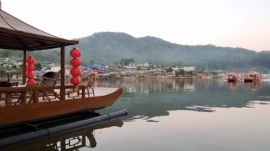 Ban Rak Thai, Mae Hong Son, Tayland -23 Ocak 2022: Turistler gölü görmek için tekneyle gezerler ve suyun üzerinde yüzen sisli ve güzel huzurlu köy Ban Rak Thai, Mae Hong Son, kuzey Tayland.