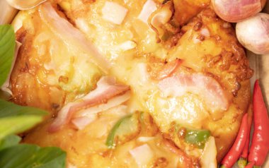 Pizzanın arka planında taze kırmızı biber, sarımsak ve arpacık soğanı var..