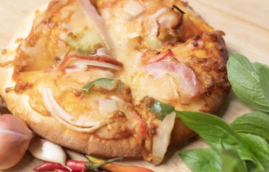 Pizzanın arka planında taze kırmızı biber, sarımsak ve arpacık soğanı var..