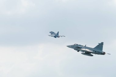 İki savaş uçağı gökyüzünde fotokopi uzayı ile teknoloji arka planında uçuyor.