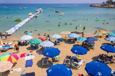 Protaras, Paralimni, Kıbrıs, 26 Ağustos 2023: Fig Tree Körfezi plajında renkli plaj şemsiyeleri 