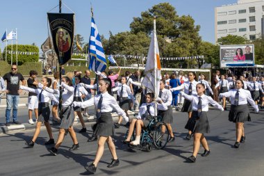 Limasol, Kıbrıs, 28 Ekim 2023: Ohi Günü geçit töreninde üzerinde Yunan ve Kıbrıs Rum bayrakları ve bayrağı bulunan okul kızları