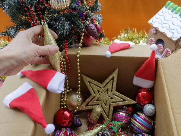 Karton kutudan Noel süslemeleri çıkarıyorum.