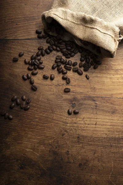 Ahşap arka planda kahve çekirdekleri, yakın plan. Üst görünüm, boşluk kopyala 