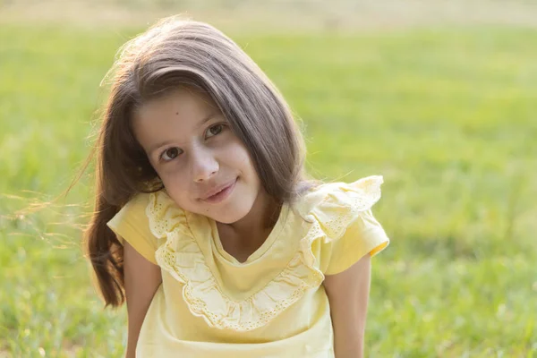 Yazın çimenlerin üzerinde sarı gözlü kız.