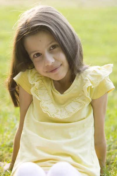 Yeşil çimlerin üzerinde gülümseyen güzel kız.