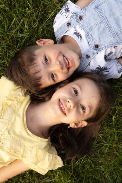 Dwoje Uroczych Uśmiechniętych Dzieci Leżących Trawie — Zdjęcie stockowe