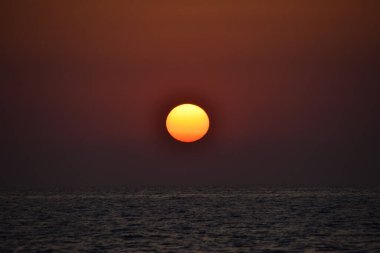 Denizin üzerinde gün doğumu, bulutsuz açık gökyüzü. Altın saat.