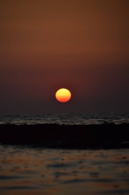 Denizin üzerinde gün doğumu, bulutsuz açık gökyüzü. Altın saat.