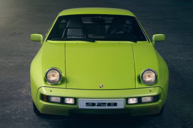 Neu-Ulm, Almanya - 23 Aralık 2022: Porsche 928 spor arabası. Ön manzara, farlar açık..