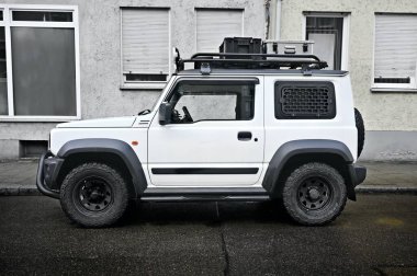 Neu-Ulm, Bavaria, Germany - December, 01, 2022: Tuned Suzuki Jimny parked on the side of the road.