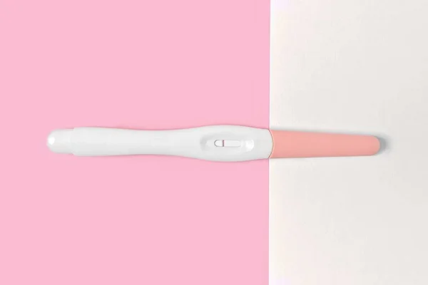 ピンクと白の背景に負のプラスチック妊娠テスト — ストック写真