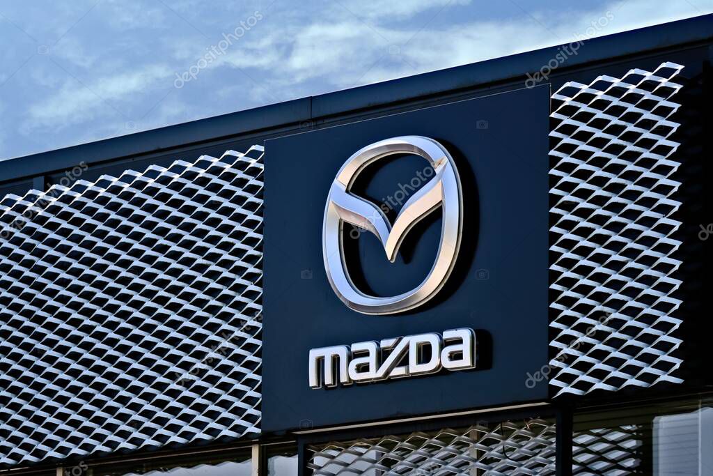 Neu-Ulm, Bavaria, Germany - June, 14, 2023: Mazda Car Dealership Sign Against Cloudy Sky.