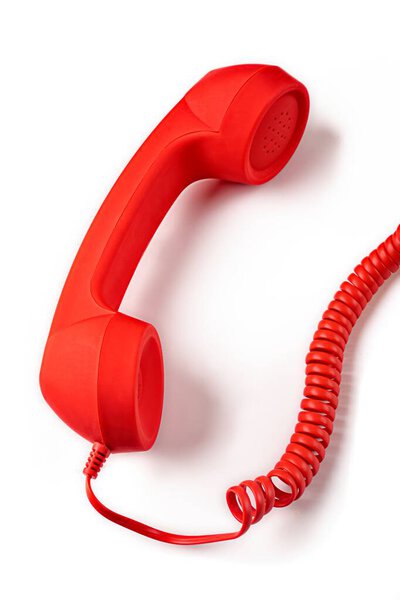 Red handset of a vintage phone isolated on white background. Vertical image