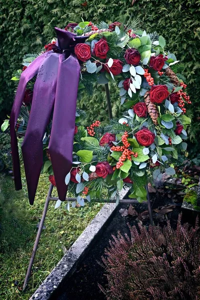 Funeral rose wreath on the cemetery. Vertical image.