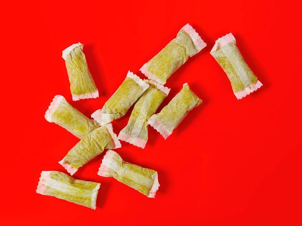 Close-up of Snus Nicotine pouches on red background.
