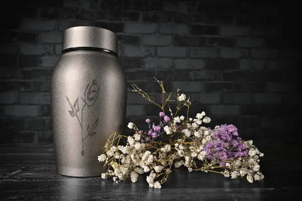 Kül vazosu bir demet çiçeğin yanında..