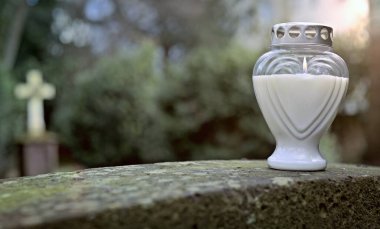 Eski mezar taşının önündeki bir mezarda kalp şeklinde bir mezarlık mumu. Kopyalama alanı olan panoramik resim.