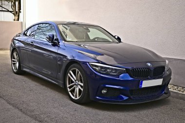 Neu-Ulm, Almanya - 20 Mart 2025: Arka bahçeye park edilmiş mavi BMW M4.