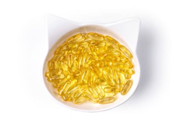 Beyaz arka planda izole edilmiş balık yağı omega 3 haplarıyla dolu yüksek açılı beslenme çanağı manzarası.