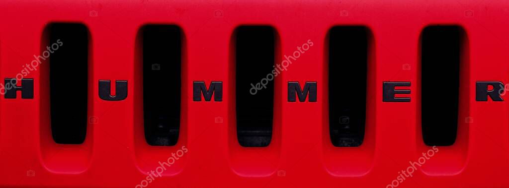 Senden, Germany - June, 04, 2025: Closeup of a HUMMER logo on the grille of a red truck. Panoramic image.
