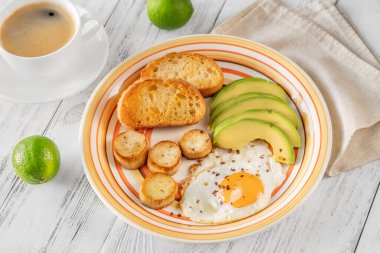 Avokadolu sahanda yumurta ve kızarmış ekmek.