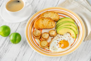 Avokadolu sahanda yumurta ve kızarmış ekmek.