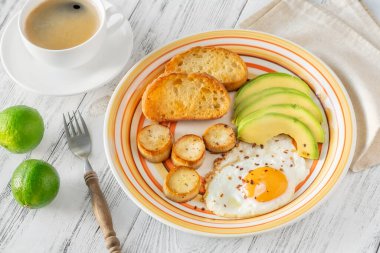 Avokadolu sahanda yumurta ve kızarmış ekmek.