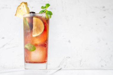 Bir bardak meyveli kokteyl, ananas dilimleriyle süslenmiş.