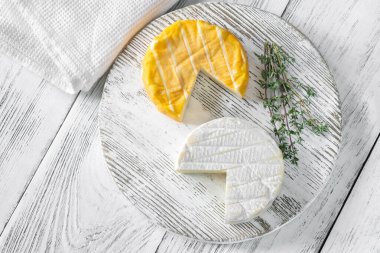 Two camembert cheese wheels on the cutting board