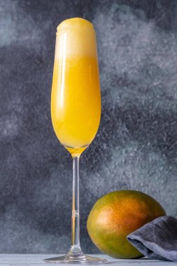 Flute Glass of Mango Mimosa cocktail on gray background