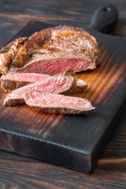 Sliced beef steak on the wooden cutting board