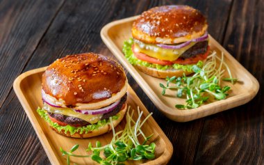 Ahşap arka planda iki jöleli burger.
