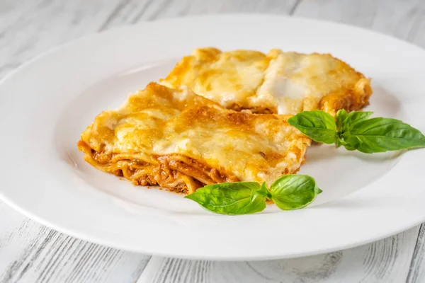 stock image Portion of traditional lasagna with basil leaves