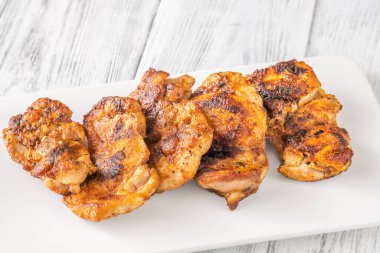 Beyaz tabakta kızarmış kırmızı biber tavuğu.