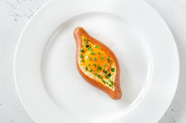 Beyaz tabağa yumurta doldurulmuş sosis.