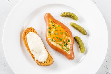 Beyaz tabağa yumurta doldurulmuş sosis.