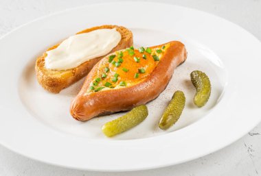 Beyaz tabağa yumurta doldurulmuş sosis.